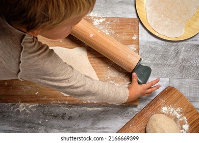 child enjoying learning to knead his family's traditional pizza 