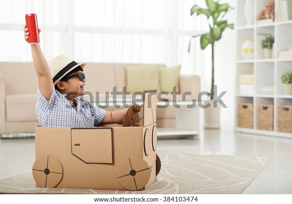 Child enjoying\
playing with his cardboard\
car