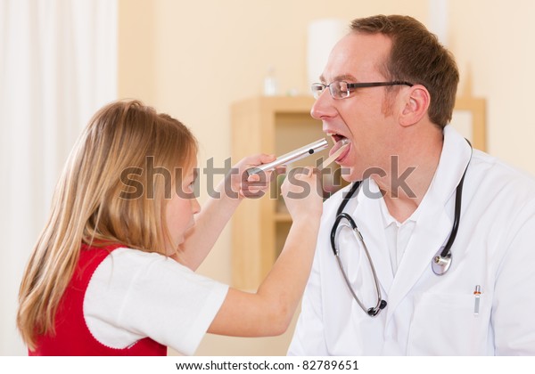Child is examining throat of her\
doctor; he tries to make her comfortable before the\
examination