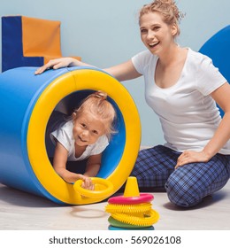 Child exercising with young therapist during occupational therapy