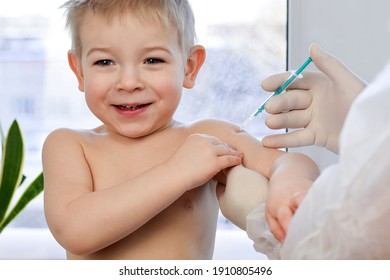 Child experiences positive emotions during vaccination. Doctor vaccinating the little smiling boy. Vaccination concept. Vaccine for covid 19 coronavirus, flu, infectious diseases. Injection.