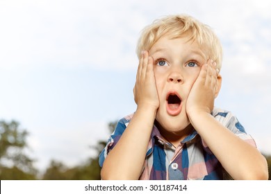 Child Expressing Surprise With Hands On His Face