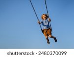 Child extreme swinging. Danger high Swing in sky. Child having fun on a swing outdoor. Craziness and freedom. Kid playing on swing-set outdoor. Playful child swinging very high to the sky.