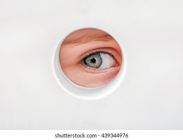 Child Eye Peeking Through A Hole