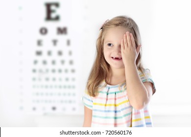 Child At Eye Sight Test. Little Kid Selecting Glasses At Optician Store. Eyesight Measurement For School Kids. Eye Wear For Children. Doctor Performing Eye Check. Girl With Spectacles At Letter Chart.