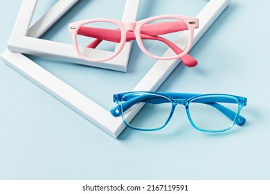 Child Eyeglasses Over Blue Pastel Background. Optical Store, Glasses Selection For Kids, Eye Test, Vision Examination At Optician Concept. Top View, Flat Lay