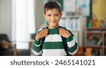 Child, face and laughing in school classroom or education with backpack for kindergarten, learning or joke. Boy, kid and portrait for study development on academy campus or student, humor or funny