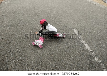 Child Falling While Roller Skating on Asphalt Road – Kid Wearing Protective Gear and Pink Helmet