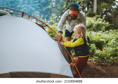 Child and father are pitching camping tent family travel vacations hiking outdoor adventure trip healthy lifestyle eco tourism - Shutterstock ID 2110004888