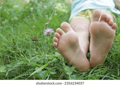 Child feet on green grass, barefoot little girl on meadow, countryside lifestyle, concept of grounding and connecting with nature - Shutterstock ID 2356234037
