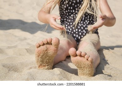 Child feet in the sand on a beach. Summer vacation on seaside.