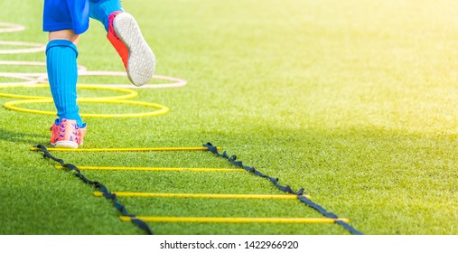 Child Feet With Soccer Boots Training On Agility Speed Ladder In Soccer Training.