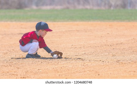 Child Fields a Ground Ball During a Baseball Game