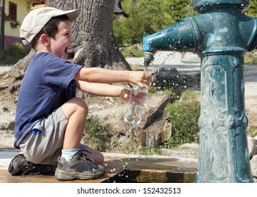 Child Filling Water Bottle From A Hydrant Fountain. 