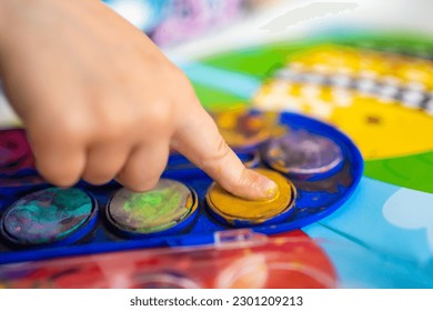 The child fills in the empty spaces. Ideas for finger painting. Finger painting task for kids. Little girl draws with paints. children development concept. High quality photo - Powered by Shutterstock