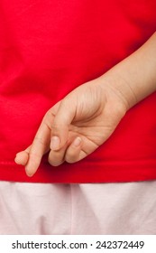 Child With Fingers Crossed Behind Her Back To Excuse Telling A Lie  