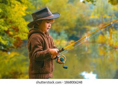 Child fishing at autumn lake. Kid with fishingrod