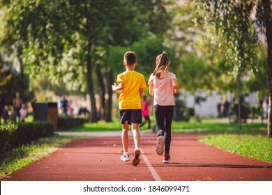 Child fitness, twins kids running on stadium track in city park , training and children sport healthy lifestyle. Outdoor activities by running make the child's body healthy and experience enriched.