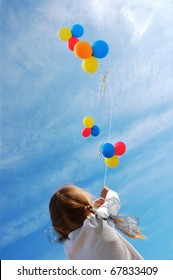 child flying colorful balloons in the blue sky