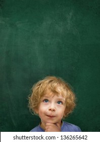 Child In Front Of A Green Chalkboard