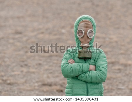 Child in a gas mask on a deserted field. Apocalypse postnuclear Doomsday scenario