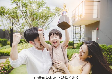 Child Get Win Of Sport And Holding Trophy Family Celebrate Son Victory Together With Smile Face And Happiness Father And Mother Get Proud Of Their Little Child Young Boy Raise Arms And Enjoy Life