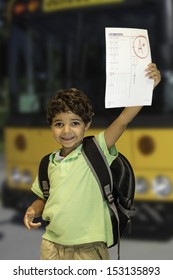 A Child Getting Off The School Bus Showing A Good Grade On Their Homework.