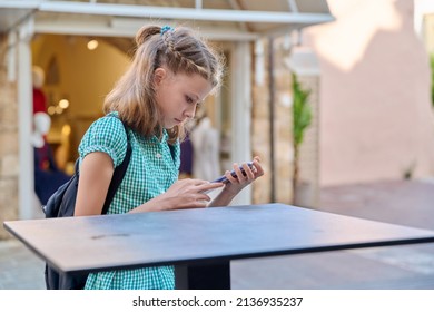 Child Girl 10, 11 Years Old With A Smartphone In The City.