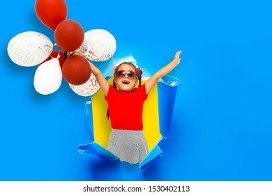 Child Girl Breaking Through Blue Paper Wall.