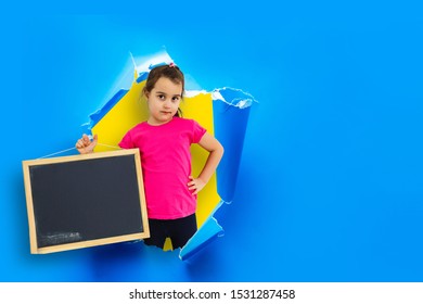 Child Girl Breaking Through Blue Paper Wall.