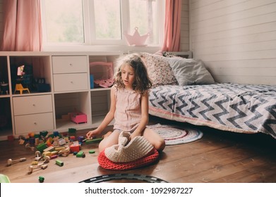 Child Girl Cleaning Her Messy Room And Put Toys In Basket