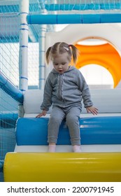 Child Girl Climbing Down Ramp In Soft Play Centre