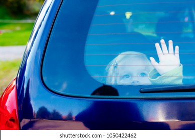 Child Girl Closed Alone In The Back Of A Parking Car On A Hot Day. Concept Image Of Danger Of Overheating In Car For Young Children In The Summer