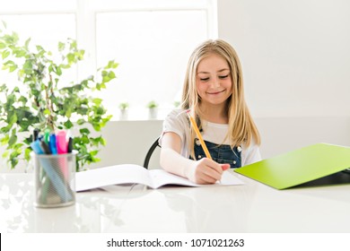 Child Girl Doing Homework At Home Kitchen Table