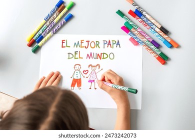 child girl drawing picture for dad on father's day holiday, dad and child and colorful text the best dad in the world in Spanish. - Powered by Shutterstock