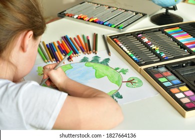 Child Girl Draws Planet For Earth Day. Protection Of Enviroment, Save Our Planet. Concept Of Art Learning And Education, Love Earth , Save World And Unity.Ecology Concept.Selective Focus