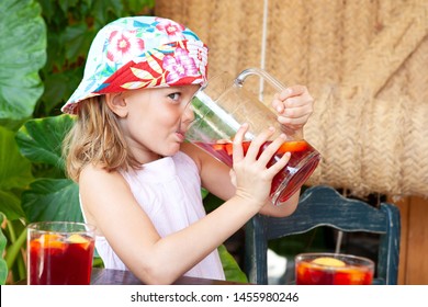 Child Girl Drinking From Jug In Summer Holiday Villa Garden Table, Fresh Fruit Juice Outdoors. Beautiful Family Food And Drink On Vacation Hotel Restaurant, Travel Leisure Recreation Lifestyle.