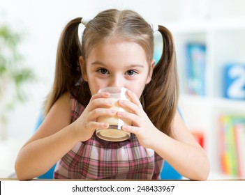 Child Girl Drinking Milk From Glass Indoors