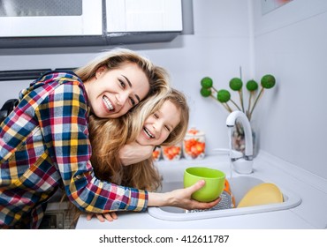 Child Girl Five Years Old Drinking Water From Glass Under The Supervision Of A Beautiful Young Woman