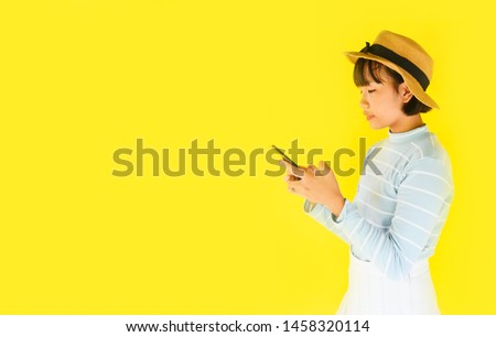 child girl hands holding smartphone on yellow background / Asian young woman using mobile phone fashion pretty in the summer and holiday