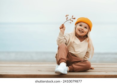 Child girl happy smiling outdoor walking on the beach kid 4 years old in yellow hat family travel vacations autumn season - Powered by Shutterstock