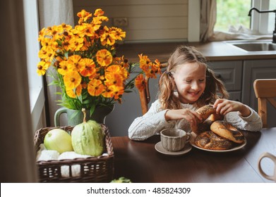 Child Girl Having Breakfast At Home In Autumn Morning. Real Life Cozy Modern Interior In Country House. Kid Eating Bagels And Drinking Tea. 