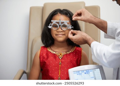 Child girl having her eyes tested by an eye care professional, wearing eyeglasses visual acuity test at eye clinic or optometrist’s office - Powered by Shutterstock