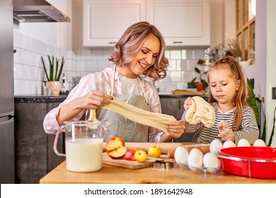 Child Girl Knead With Mom In The Kitchen, Going To Bake Delicious Cookies. Family At Home At Weekend, Mother Teach Child Girl To Cook