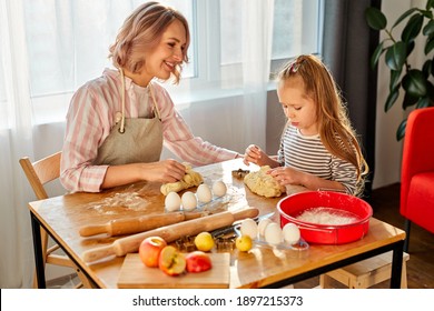 Child Girl Knead With Mom In The Kitchen, Going To Bake Delicious Cookies. Family At Home At Weekend, Mother Teach Child Girl To Cook