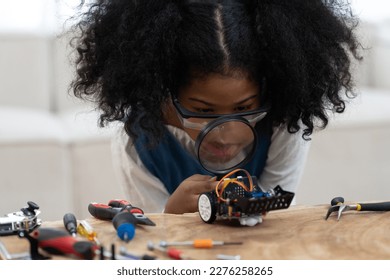 Child girl learning toy robotics technology through magnifying glass. Adorable young girl building robotic toy car in classroom at school. Education and technology concept   - Powered by Shutterstock