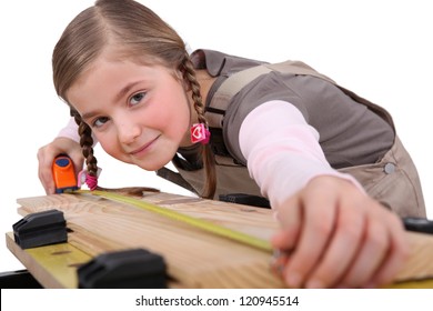 A Child Girl Measuring A Plank