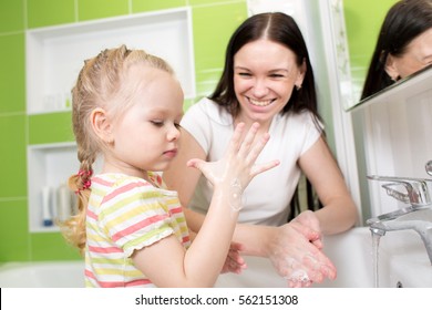 Child Girl And Mother Washing Hands With Soap In Bathroom