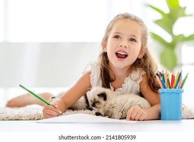 Child girl painting and ragdoll kittens the floor   imagining  Little female person drawing and colorful pencils   kitty pets close to her at home