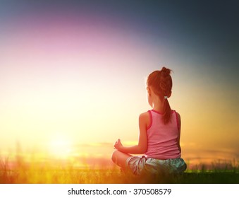 Child girl in the Park. Yoga at sunset in the park. Girl is practicing yoga. - Powered by Shutterstock